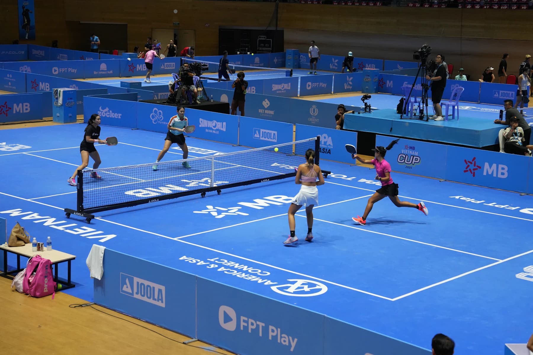 Four pickleball players competing on a blue court